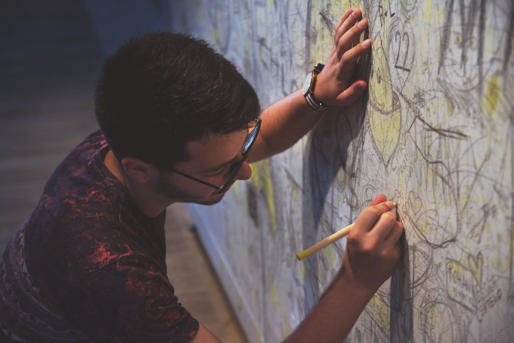Image of young man drawing on a wall